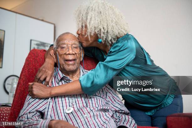 senior woman giving her 91 year old father a kiss on the head - 90 year old stockfoto's en -beelden