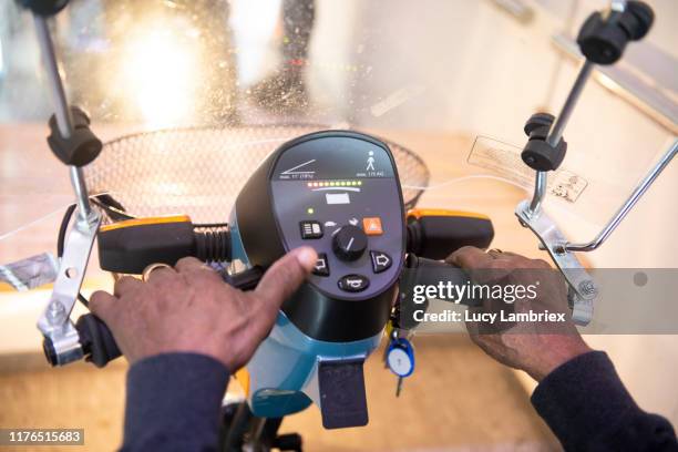 first person perspective of a 91 year old man riding his mobility scooter indoors - 90 year old stockfoto's en -beelden