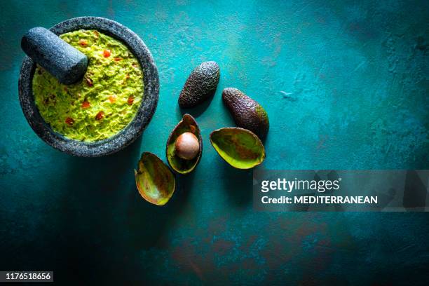 guacamole prepared in molcajete with avocado - guacamole stock pictures, royalty-free photos & images