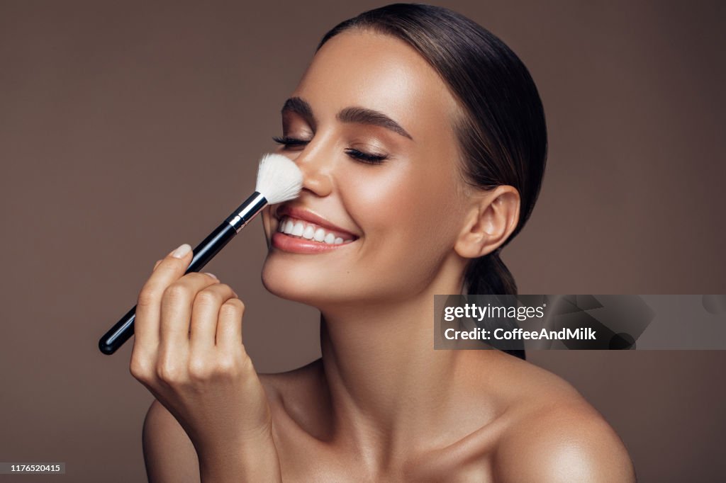 Hermosa mujer aplicando maquillaje