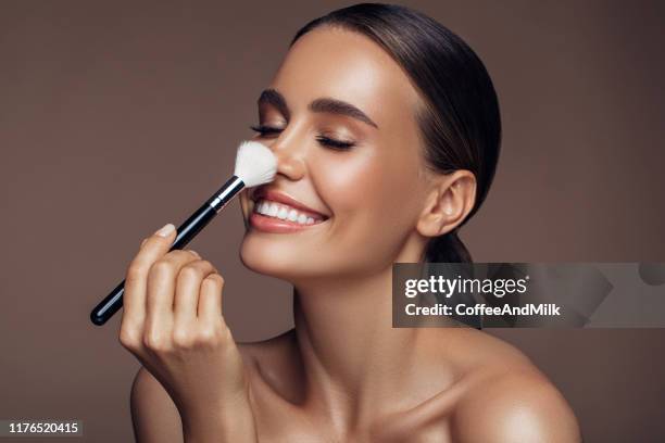 belle femme appliquant le maquillage - woman hand face photos et images de collection