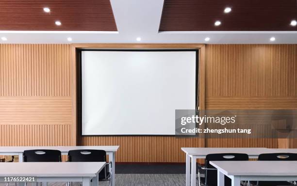 my empty lecture hall with blank projection screen - projector classroom photos et images de collection