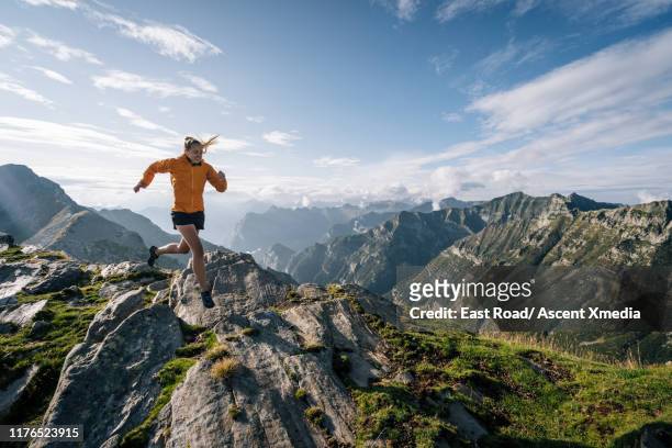 trail runner traverses summit ridge crest - cross country running 個照片及圖片檔