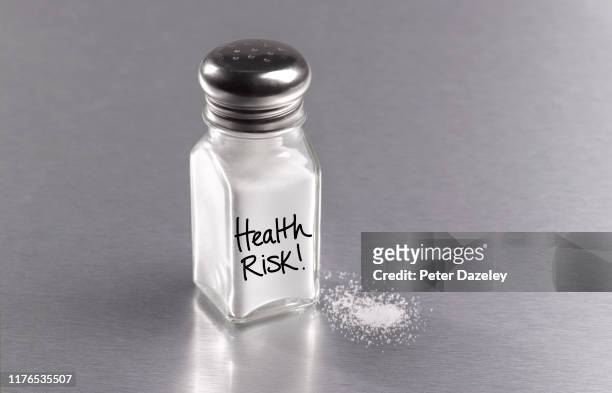 salt in salt cellar with spilt salt, warning health risk - salt seasoning stock pictures, royalty-free photos & images