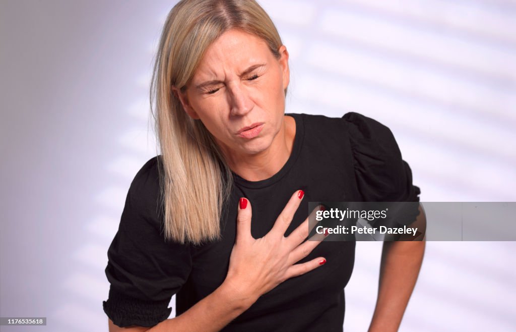 Adult woman clutching heart in pain