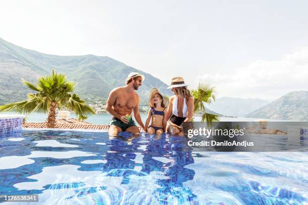 familie mit einer tochter, die spaß im schwimmbad hat - family beach holiday stock-fotos und bilder