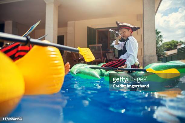 kleine jungs spielen piraten - kids pool games stock-fotos und bilder