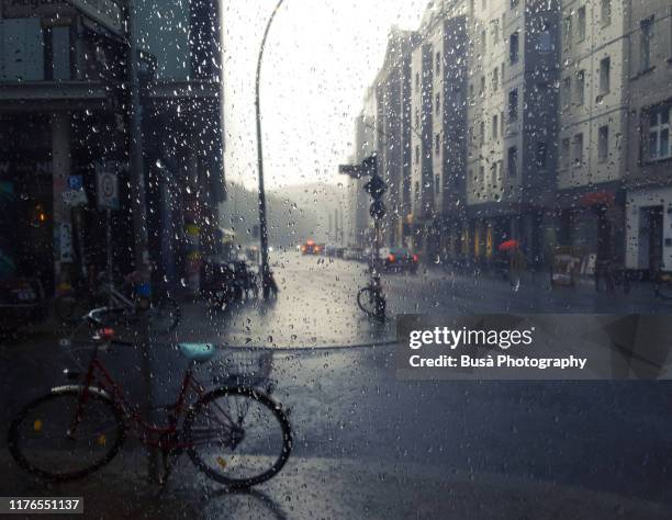 view through window of rain in the streets of berlin, germany - berlin weather stock pictures, royalty-free photos & images