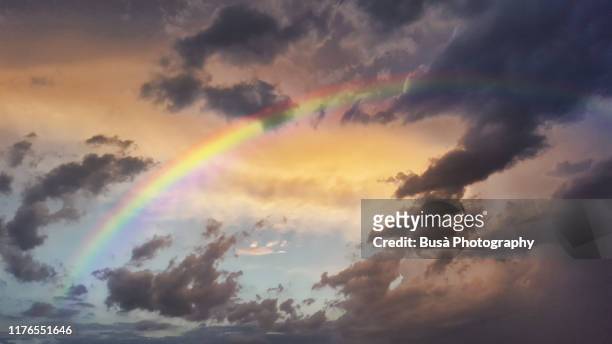 storm clouds and rainbow at sunset - hoffnung stock-fotos und bilder