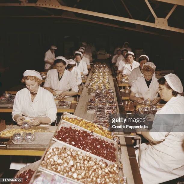 Line of female employees wrap and prepare easter eggs on a production line at a Cadbury's confectionary factory in England in April 1958.