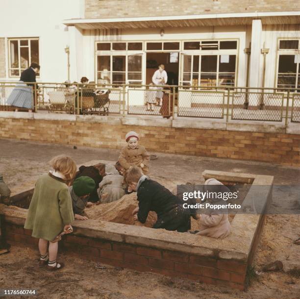 Group of young children play in a sandpit in an outside play area at the Brentwood Recuperation Centre, a residential centre for mothers and children...