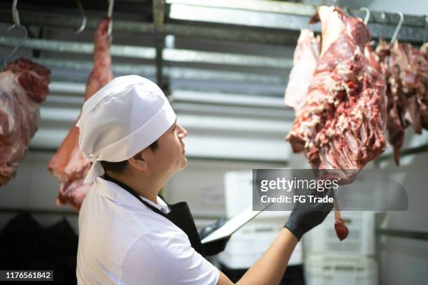 butcher analyzing meat in a meat locker - freezer stock pictures, royalty-free photos & images
