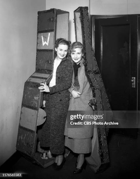 Fred Waring, conductor and band leader gets ready for a CBS Radio broadcast. Left to right, Rosemary and Priscilla Lane. December 1, 1933.