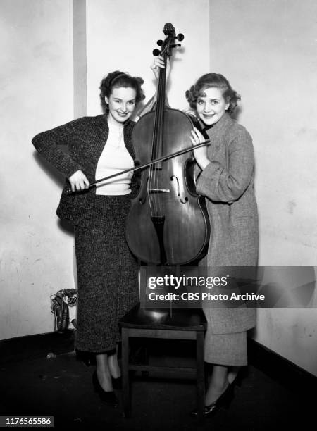 Fred Waring, conductor and band leader gets ready for a CBS Radio broadcast. Left to right, Rosemary and Priscilla Lane. December 1, 1933.