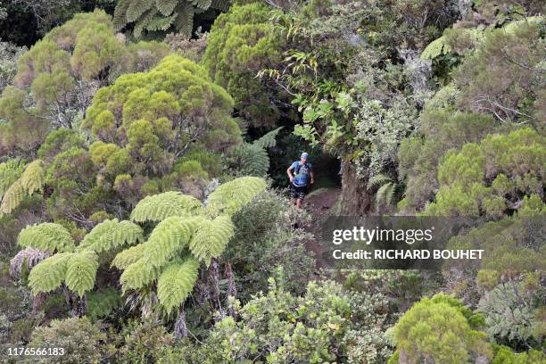 Runner competes in the Grand Raid de la Reunion ultramarathon race on October 18, 2019 in the Cirque de Mafate caldera on the French Indian ocean...