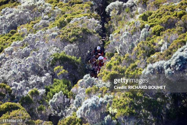 Runners compete in the Grand Raid de la Reunion ultramarathon race on October 18, 2019 in the Cirque de Mafate caldera on the French Indian ocean...