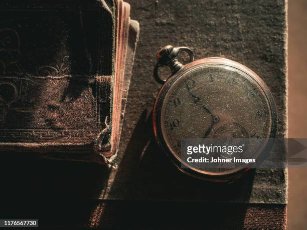 old pocket watch on book - pocket watch stock pictures, royalty-free photos & images