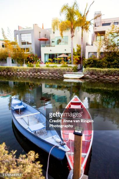 suburban houses, palm trees and canoes water in venice canal historic district in los angeles california - venice stock-fotos und bilder