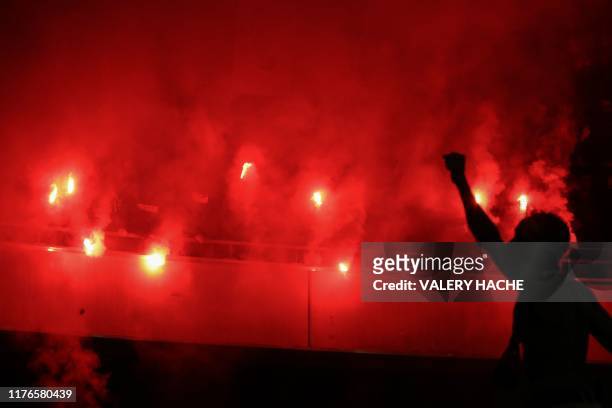 Supporters light flares during the French L1 football match between OGC Nice and Paris Saint-Germain at "Allianz Riviera" stadium in Nice, southern...