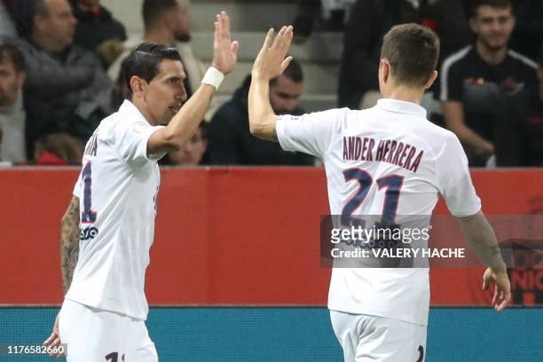Paris Saint-Germain's Argentine midfielder Angel Di Maria is congratulated by Paris Saint-Germain's Spanish midfielder Ander Herrera after scoring...