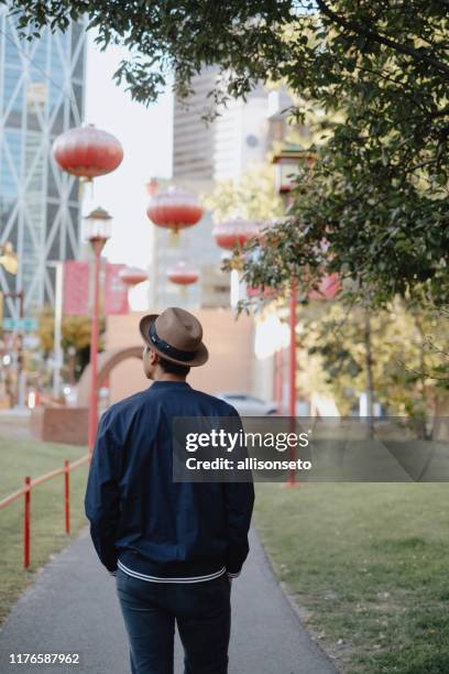 man walks through calgary chinatown - downtown calgary stock pictures, royalty-free photos & images