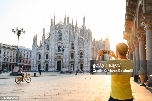 tourist photographing the cathedral (duomo) in milan with smartphone, italy - milan italy stockfoto's en -beelden