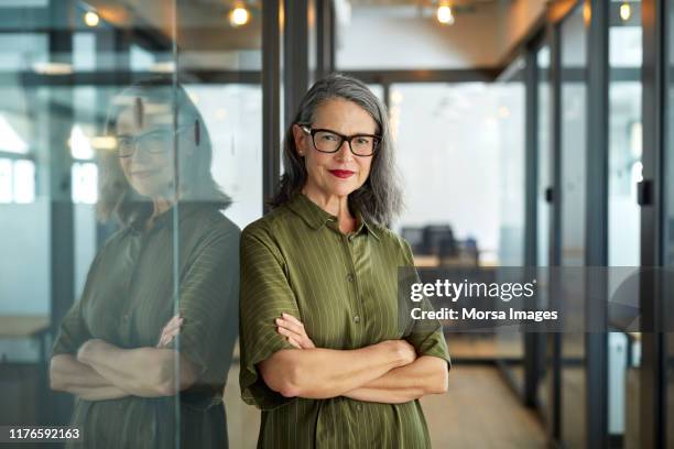 confident mature businesswoman with arms crossed - portrait work stockfoto's en -beelden