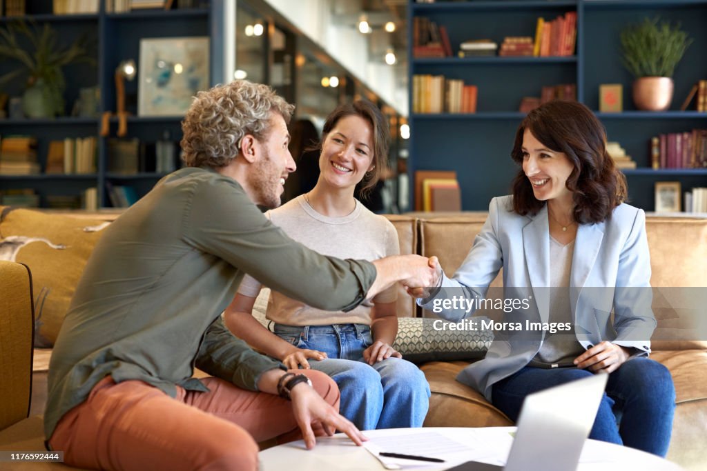 Smiling colleagues congratulating at office