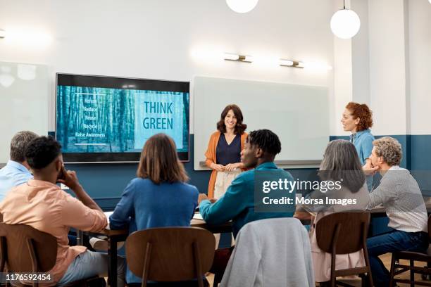 businesswoman giving presentation in board room - corporate social responsibility stock-fotos und bilder