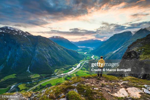 one man looking at view on top of romsdal valley, norway - guy on top of mountain stock pictures, royalty-free photos & images