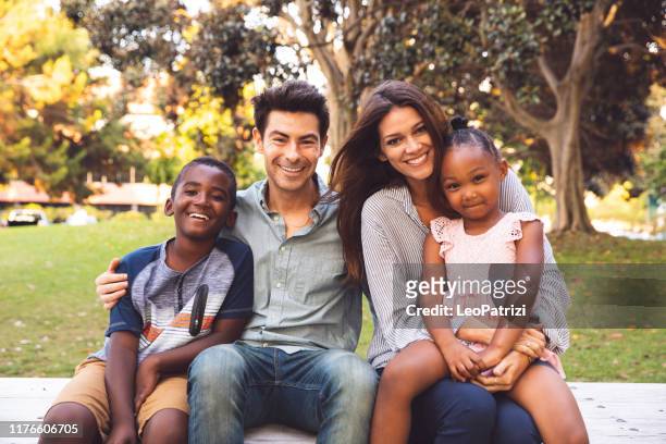 multi raciale familie met adoptiekinderen samen tijd doorbrengen in het park - diverse family stockfoto's en -beelden