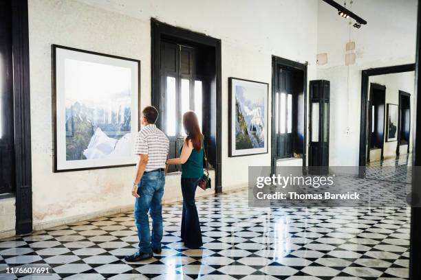 mature couple browsing artwork in art gallery - prodotto d'arte e artigianato foto e immagini stock