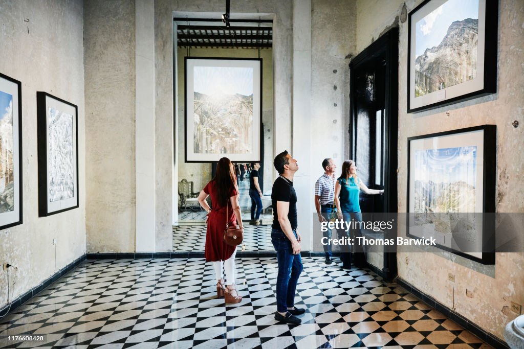 Two couples admiring artwork while touring museum during vacation