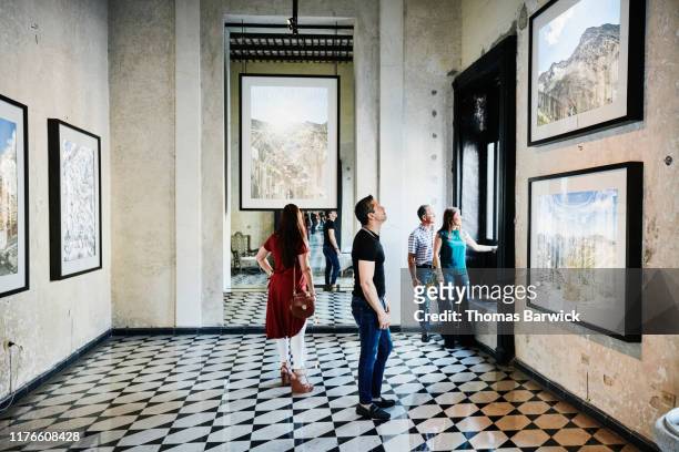 two couples admiring artwork while touring museum during vacation - exhibition foto e immagini stock