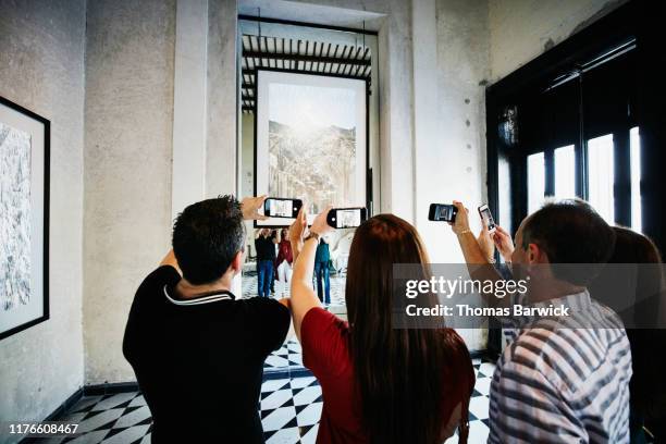 people taking photos with smart phones of artwork while touring museum - museum tour stock pictures, royalty-free photos & images