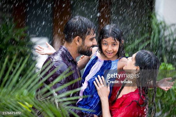 glückliche familie genießt regen - enjoy monsoon stock-fotos und bilder