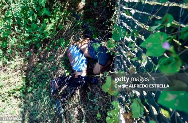 Graphic content / A corpse lies in the bush after heavily armed gunmen waged an all-out battle against Mexican security forces in Culiacan, Sinaloa...