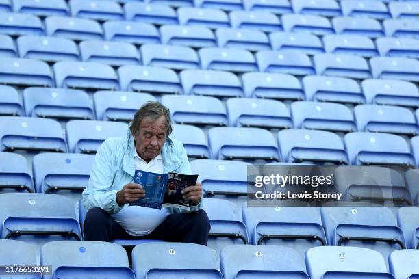 Fan of Wigan Athletic reads the match programme prior to the Sky Bet Championship match between Wigan Athletic and Charlton Athletic at DW Stadium on...