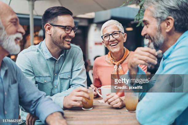 gruppo di persone sorridenti che parlano al bar - small group of people foto e immagini stock