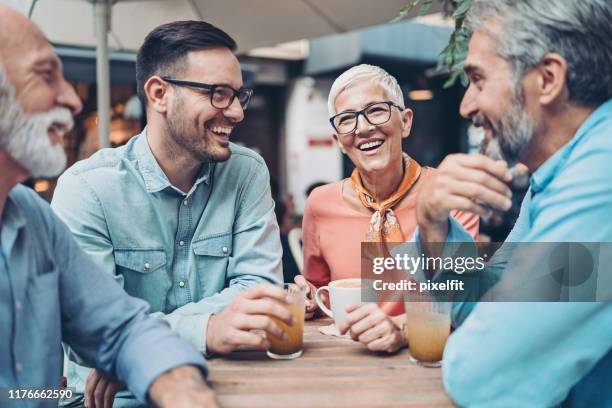 group of smiling people talking in cafe - sidewalk cafe stock pictures, royalty-free photos & images