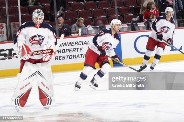 Goalie Elvis Merzlikins , Ryan Murray and Scott Harrington of the Columbus Blue Jackets warm up prior to the game against the Chicago Blackhawks at...