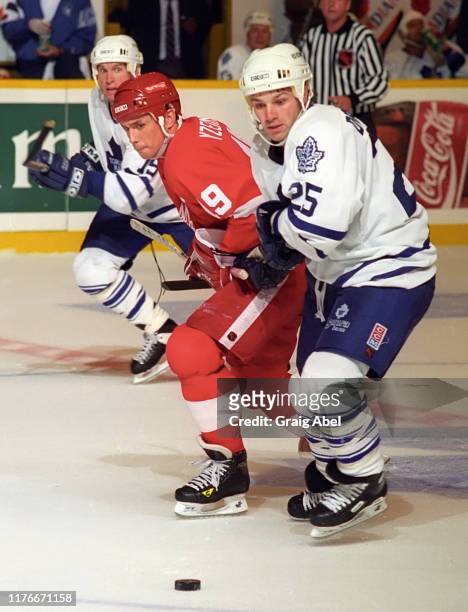 Paul DiPietro of the Toronto Maple Leafs skate against Steve Yzerman of the Detroit Red Wings during NHL preseason game action on October 1, 1995 at...