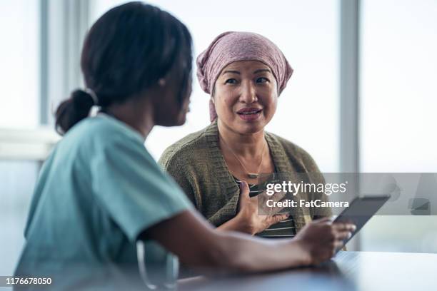 asian woman with cancer meeting with female physician - cancer support stock pictures, royalty-free photos & images