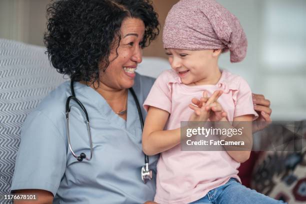 kind doctor comforts girl with cancer - leukemia stock pictures, royalty-free photos & images