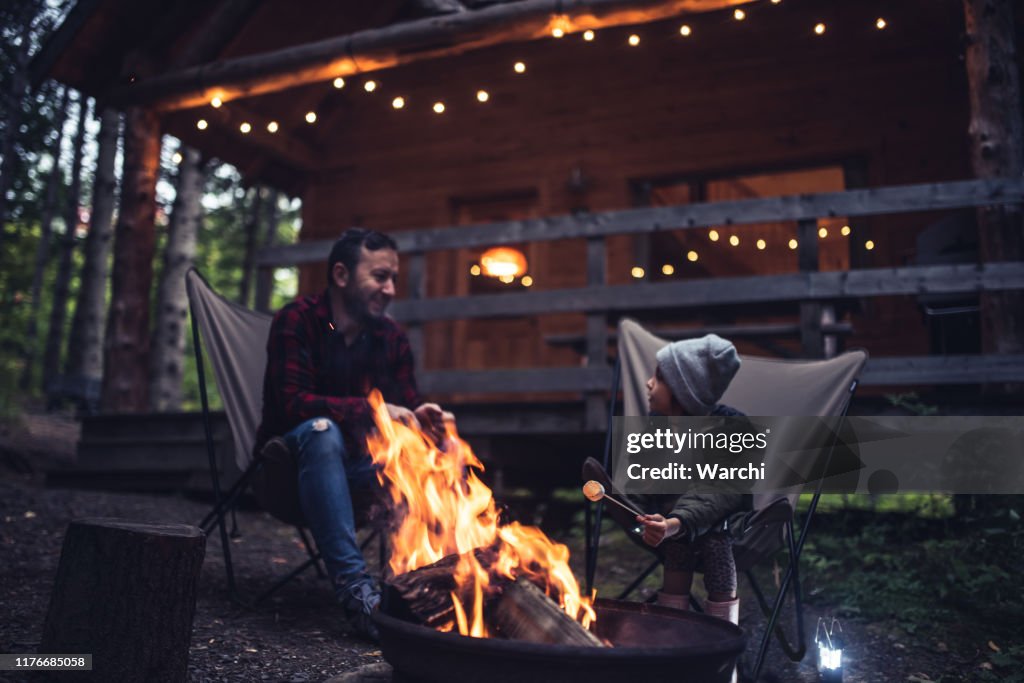 Father and daughter  having fun by the campfire