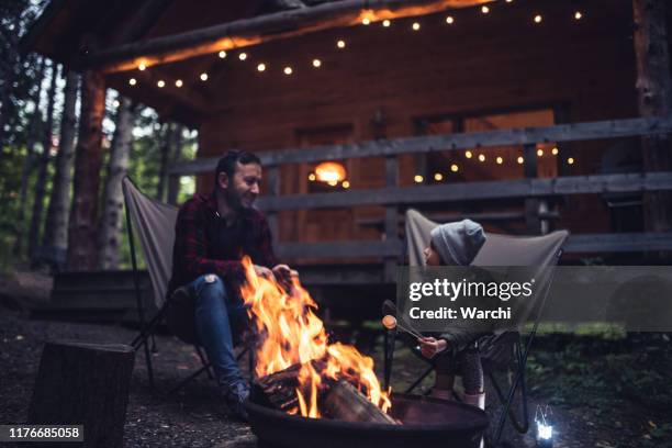 father and daughter  having fun by the campfire - cottage imagens e fotografias de stock