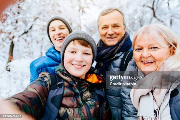 taking a family photo in winter park - grandfather child snow winter stock pictures, royalty-free photos & images