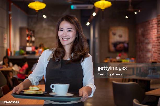 dedicated waitress holding a tray with sandwiches and tea in a coffee shop - serving tray stock pictures, royalty-free photos & images