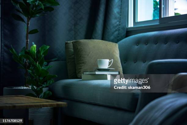 closeup coffee cup with abook at living room and copyspace - cushion stock-fotos und bilder
