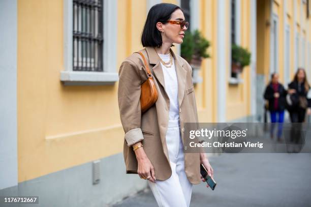 Brittany Xavier is seen wearing brown blazer, bag, white pants outside Boss during Milan Fashion Week Spring/Summer 2020 on September 22, 2019 in...